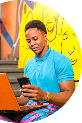 man using phone whilst busy with laptop